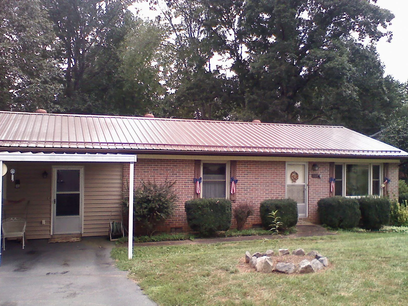 Bronze metal roof and carport on a brick ranch home — Roof Repair work by our crew in Lehigh Acres