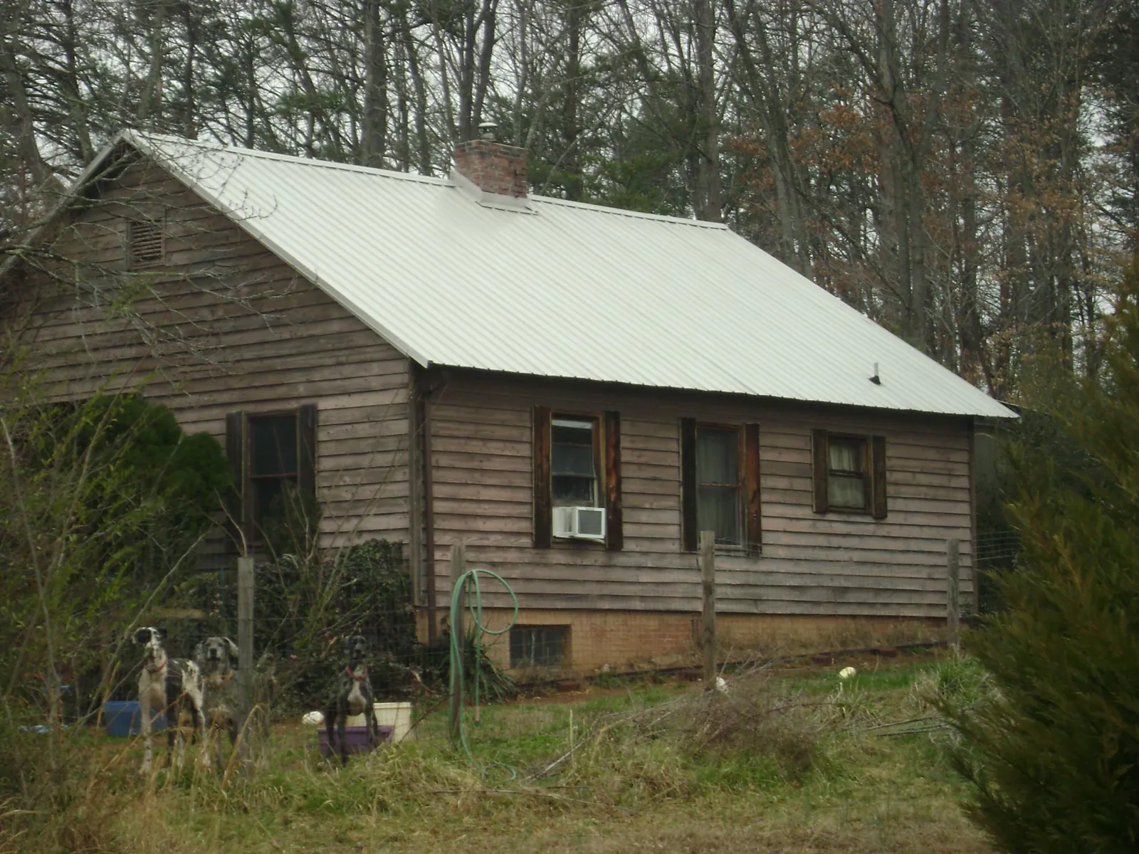 White metal roof on an old wood sided farmhouse, from a Metal Roof Installation job in Lehigh Acres